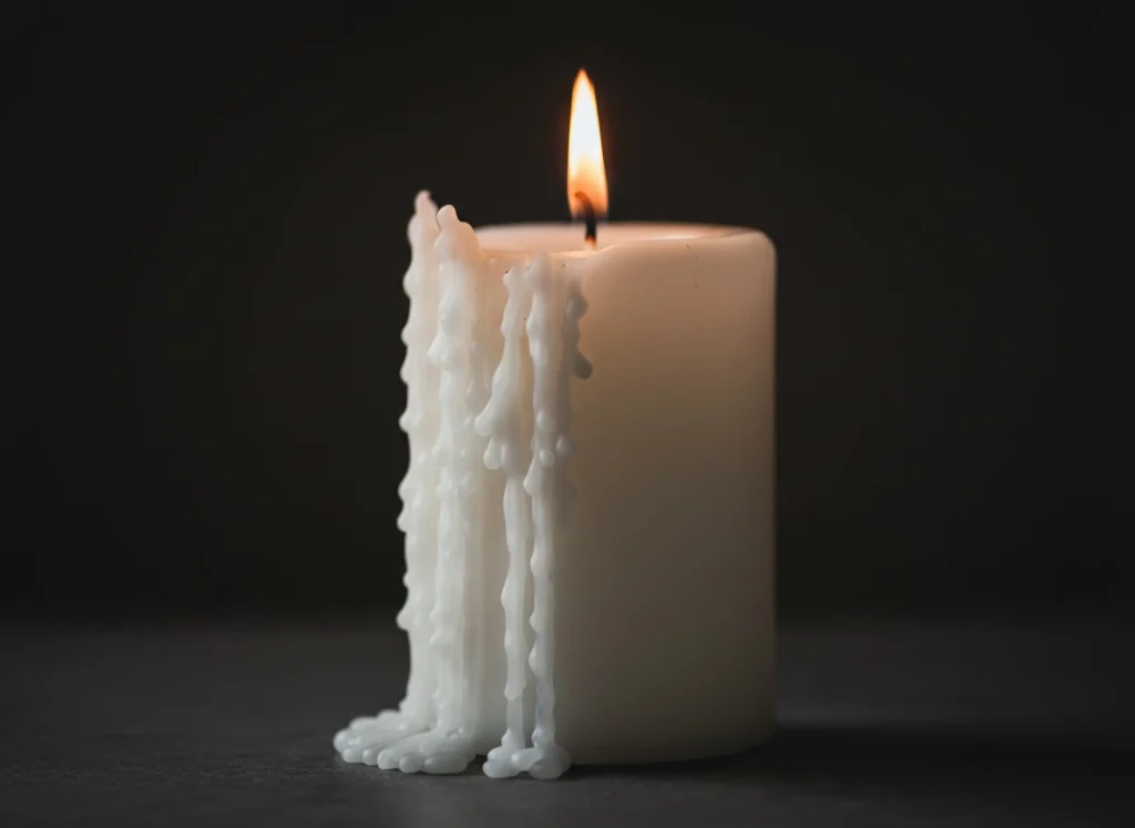 Cera derritiéndose en forma de lágrimas en una vela encendida